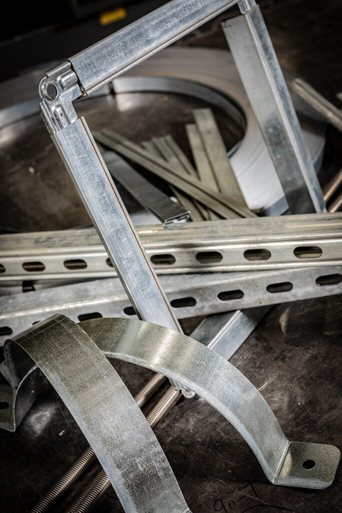 A variety of duct hangers and metal support components engineered by DuctWorx for secure, code-compliant HVAC duct installation.