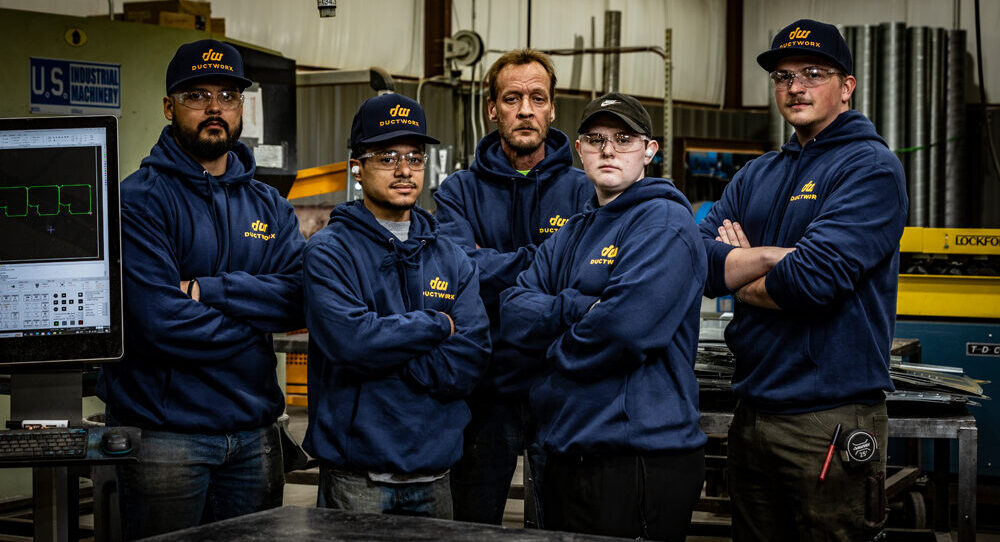 The dedicated DuctWorx team of skilled fabricators and technicians standing confidently in their Oklahoma City shop, committed to delivering custom ductwork with speed, precision and pride.